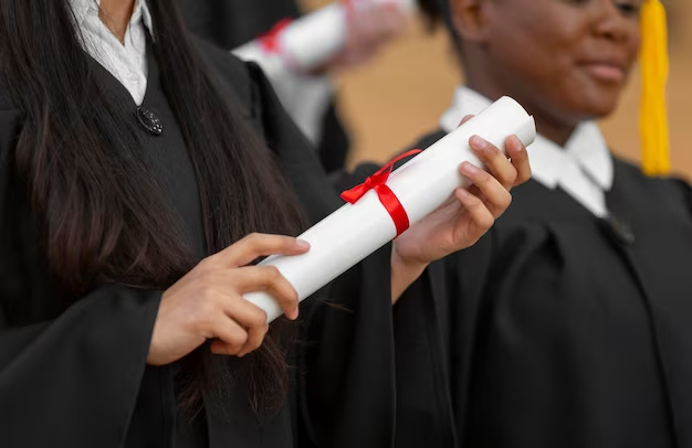 Students in graduation gowns holding diplomas