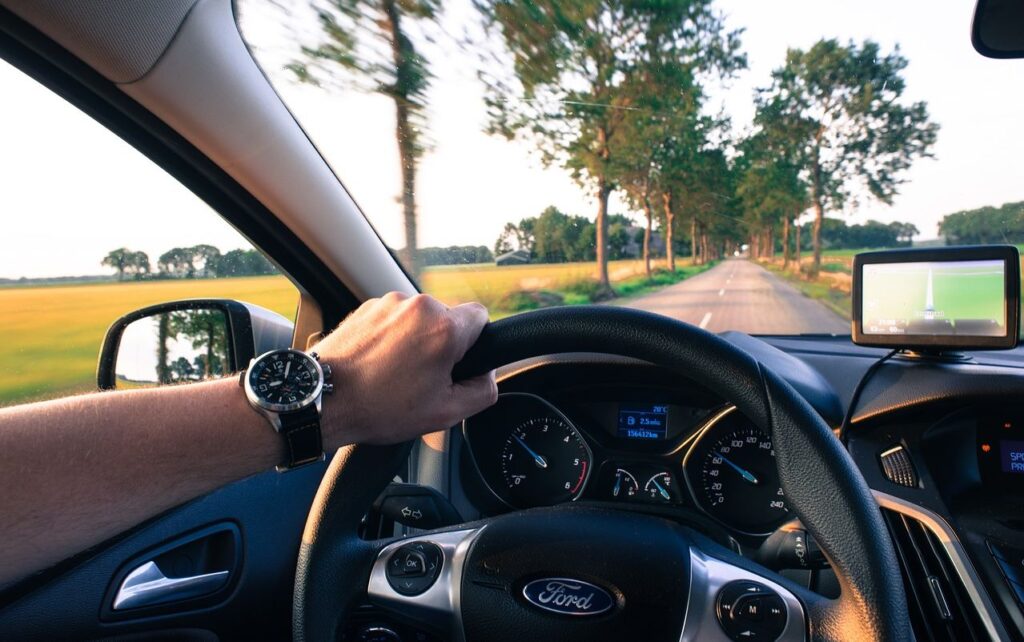 Aggressive driving in NJ: A car speeding dangerously on a highway, weaving through traffic, and tailgating other vehicles.